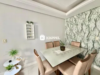 Esta é uma sala de jantar com mesa de vidro e cadeiras estofadas em um apartamento.