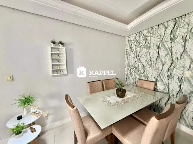 Esta é uma sala de jantar com mesa de vidro e cadeiras estofadas em um apartamento.