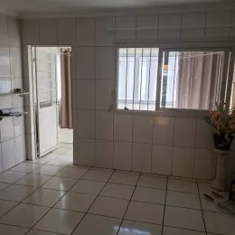 Hall de corredor com piso de cerâmica branca.