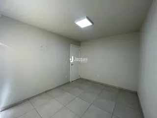Corredor interno com piso de cerâmica e paredes brancas.