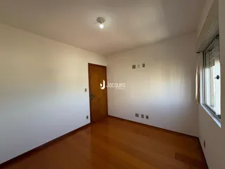 Ambiente interno de uma sala com piso de madeira clara.