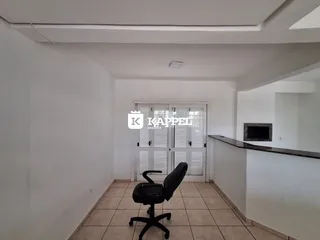 Hall de corredor com piso de cerâmica e cadeira de escritório.