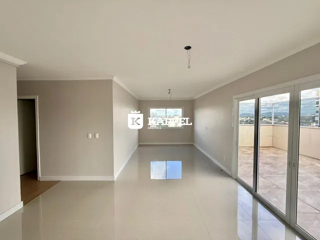 Sala ampla com piso claro e portas de vidro que dão acesso à área externa.