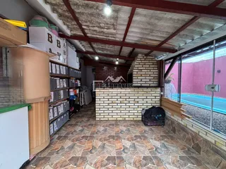 A foto mostra o interior de uma área com piso de cerâmica e paredes de tijolo.