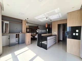 Uma sala de estar moderna com acabamentos em madeira e piso claro.