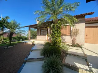 Fachada de uma casa em Lajeado, Brasil, com jardim tropical e palmeiras.