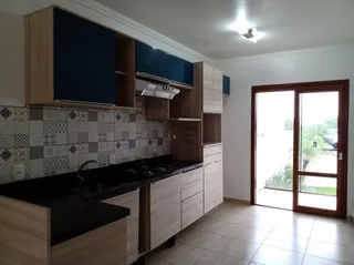 Cozinha com armários de madeira e revestimento cerâmico.