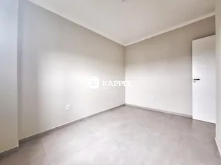 Ambiente interno com paredes brancas e piso de porcelanato claro.