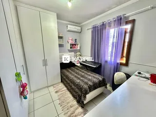 Quarto com cama e armários brancos na residência.