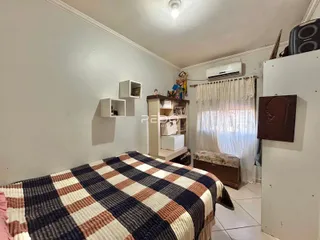 Quarto com cama e armários brancos na residência.