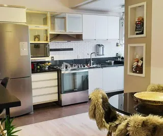 Uma cozinha moderna com armários brancos e eletrodomésticos de aço inoxidável.