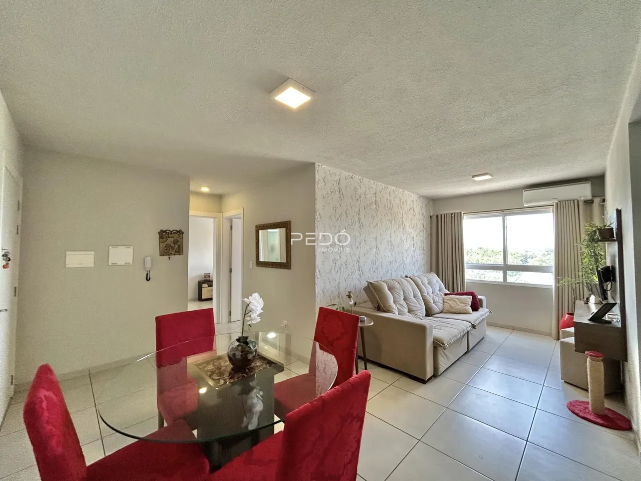 Sala de estar e jantar com sofá e mesa de jantar em um apartamento.