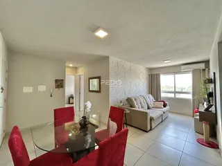 Sala de estar e jantar com sofá e mesa de jantar em um apartamento.