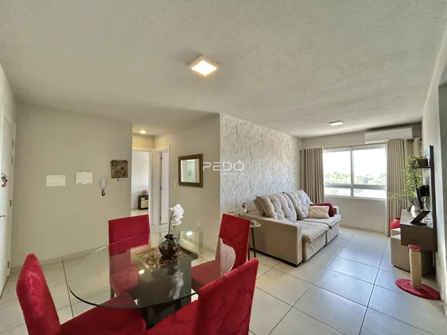Sala de estar e jantar com sofá e mesa de jantar em um apartamento.