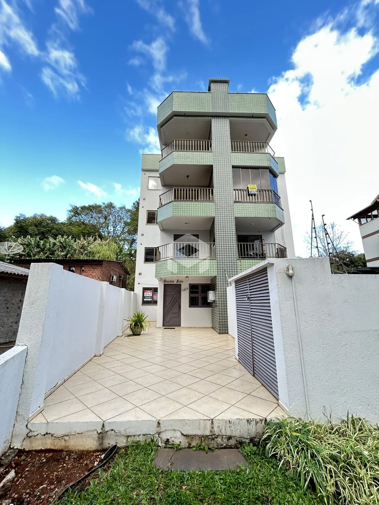 Fachada de um prédio residencial em Lajeado, Brasil, com um pátio frontal.