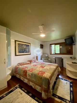 Quarto com cama e decoração em madeira no interior de uma residência.