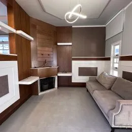 Sala de estar com painel de madeira e lareira.