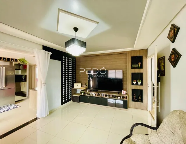 Sala de estar com piso claro e painel de madeira na residência.