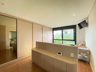 Quarto com armários embutidos e piso de madeira em um imóvel no Brasil.