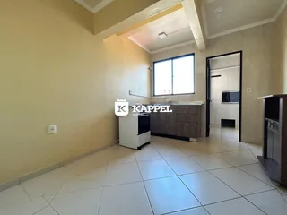 Vista interna de uma sala com piso de cerâmica e janela.
