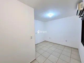 Interior de uma sala com piso de cerâmica clara e paredes brancas.