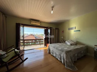 Quarto com piso de madeira e porta de vidro abrindo para o exterior.