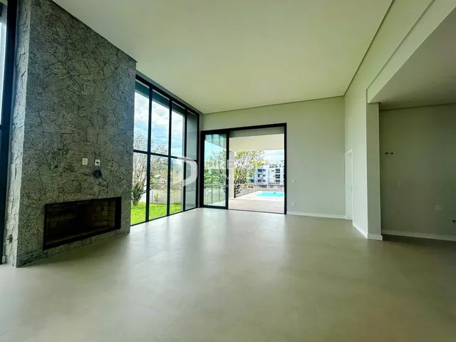 Sala de estar ampla com piso claro e parede de pedra.