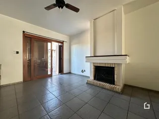 Sala de estar com piso de cerâmica e porta de madeira.