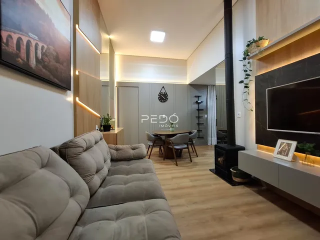Sala de estar moderna com piso de madeira e lareira em um imóvel no Brasil.