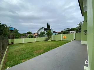 Vista externa de um quintal gramado e muro verde em Lajeado, Brasil.