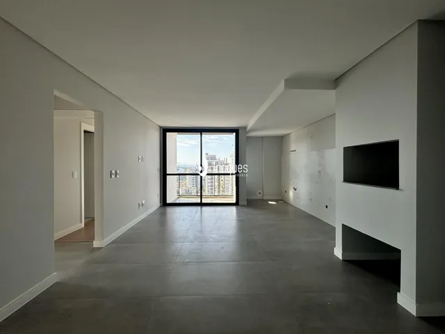 Sala de estar com piso de concreto e vista para a cidade.
