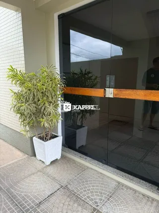 Vista da entrada de uma propriedade em Lajeado, Brasil, mostrando um vaso de planta e uma porta de vidro.