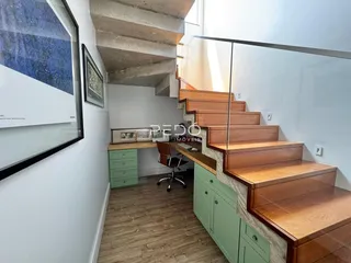 Ambiente interno mostrando uma escadaria com detalhes em madeira e revestimento.