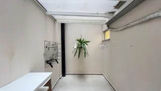 Corredor interno com paredes brancas e piso de cerâmica.