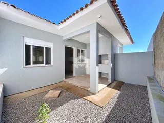 Fachada externa de uma casa em Lajeado, Brasil, com paredes cinzas e telhado de telhas.