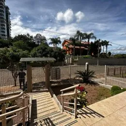 Área externa com deck de madeira e paisagismo em uma residência.