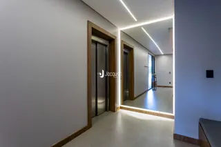 Hall de entrada moderno com portas de madeira e iluminação em LED.