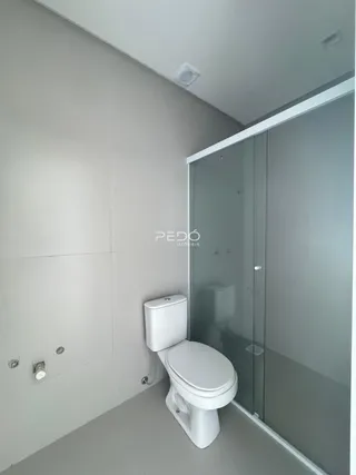 Foto de um banheiro moderno com box de vidro e vaso sanitário.