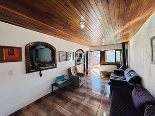 A sala de estar apresenta um teto de madeira e piso de cerâmica.