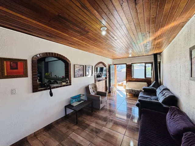 A sala de estar apresenta um teto de madeira e piso de cerâmica.