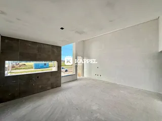 A foto exibe um espaço interno amplo com piso de concreto aparente.
