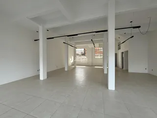 Hall de entrada amplo com piso claro e paredes brancas.
