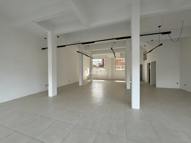Hall de entrada amplo com piso claro e paredes brancas.