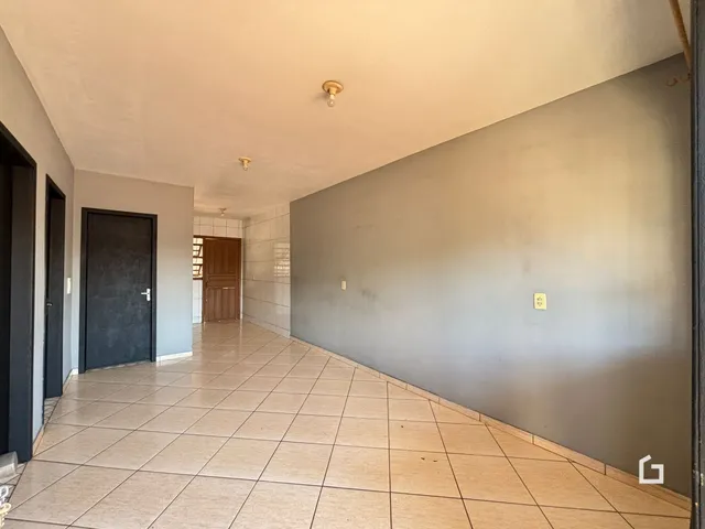 Corredor interno de uma residência com piso de cerâmica.