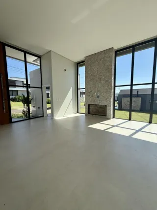 Sala ampla com grandes janelas de vidro que dão vista para o exterior.