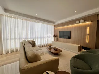 Sala de estar moderna com sofá e decoração em tons neutros.