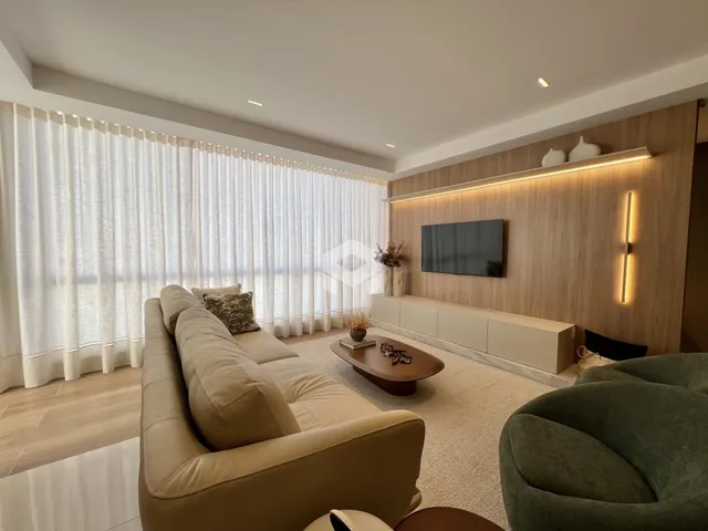 Sala de estar moderna com sofá e decoração em tons neutros.