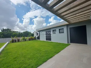 Fachada de uma casa com jardim gramado e garagem.