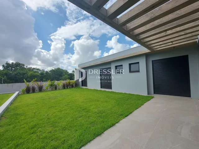 Fachada de uma casa com jardim gramado e garagem.