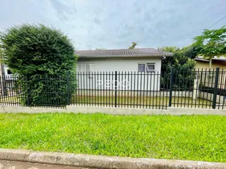 Fachada de uma residência com cerca de ferro e gramado em Lajeado.